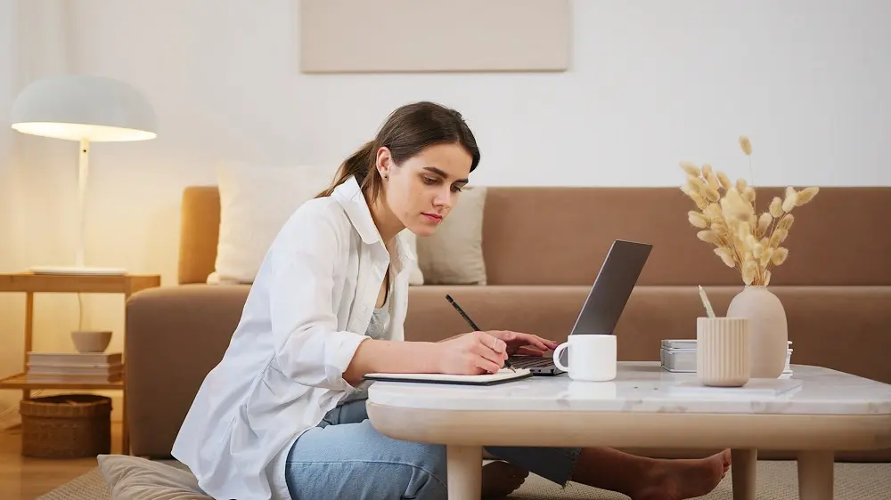 Mujer estudiando en casa, decorando su espacio con estilo y comodidad para aprender en línea.